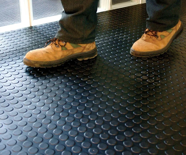 Black coin-patterned rubber flooring in a Dubai interior.